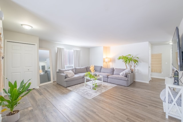 living room with baseboards and light wood finished floors