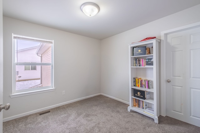 spare room featuring visible vents, carpet floors, and baseboards