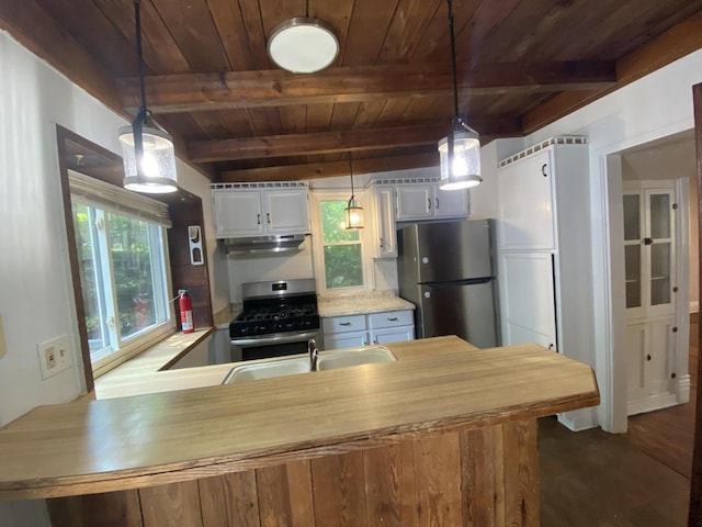 kitchen featuring beamed ceiling, pendant lighting, and stainless steel appliances