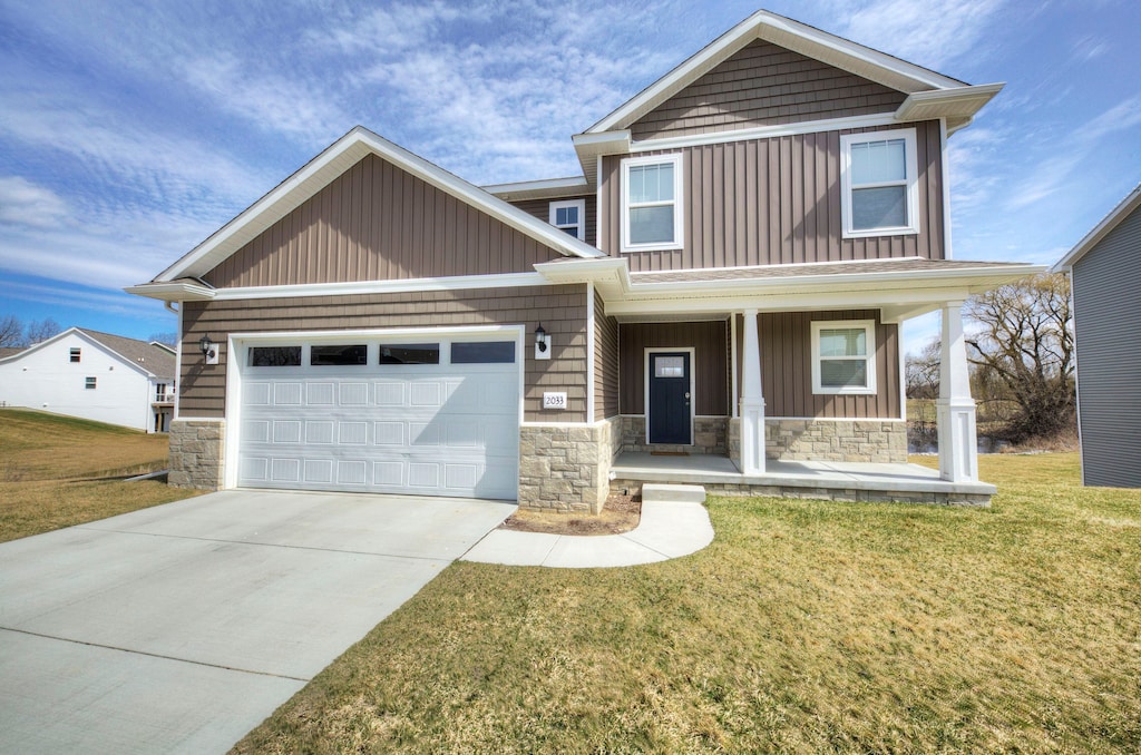 craftsman-style house featuring a front lawn, a porch, and a garage