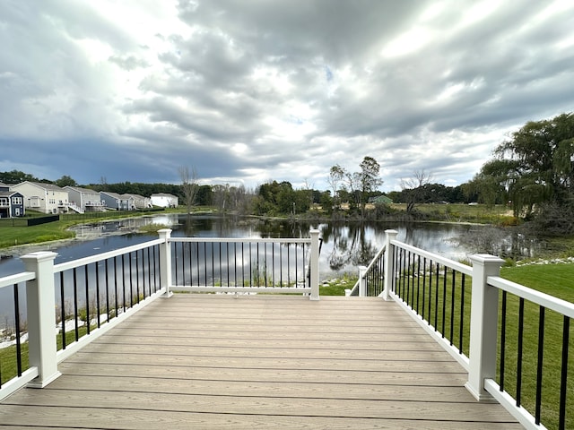 wooden deck featuring a water view and a yard