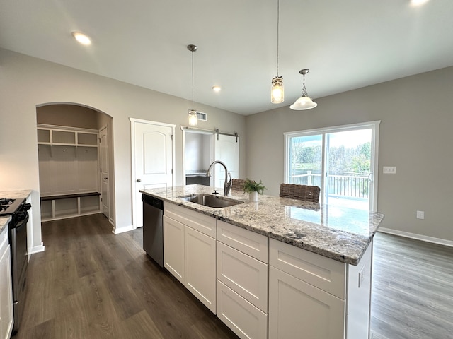 kitchen with dishwasher, sink, a barn door, decorative light fixtures, and white cabinetry