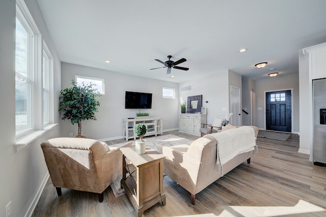 living room with a wealth of natural light, hardwood / wood-style floors, and ceiling fan