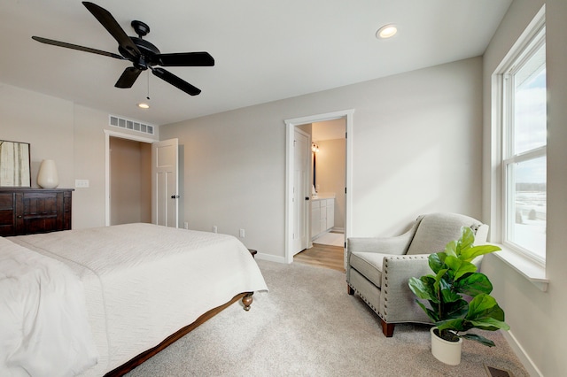 carpeted bedroom featuring ceiling fan and ensuite bath