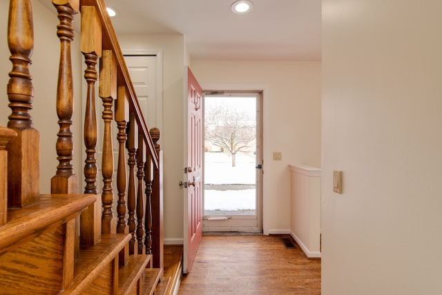 doorway with wood-type flooring and a healthy amount of sunlight