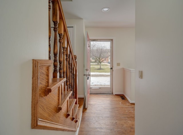 doorway with recessed lighting, visible vents, light wood-style flooring, baseboards, and stairs