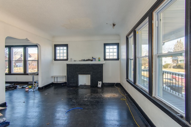 unfurnished living room featuring a textured ceiling, dark hardwood / wood-style floors, and a fireplace