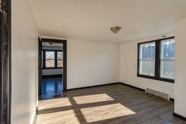 unfurnished room with a wealth of natural light and dark wood-type flooring