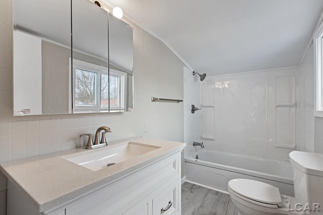 full bathroom with hardwood / wood-style floors, vanity, shower / tub combination, toilet, and tasteful backsplash