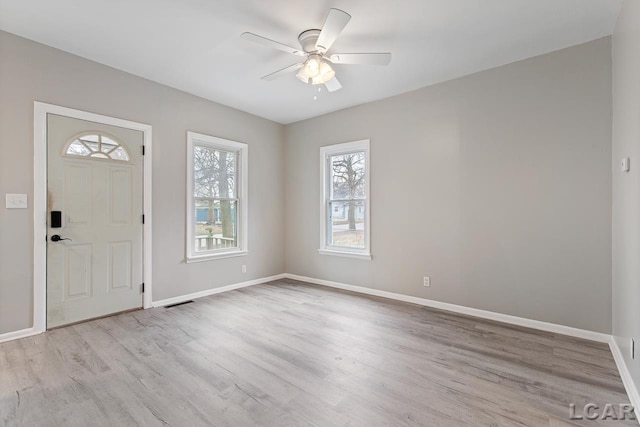 entrance foyer featuring light wood-type flooring, ceiling fan, and a healthy amount of sunlight