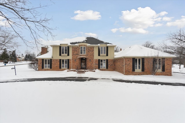 view of front of property featuring brick siding and a chimney