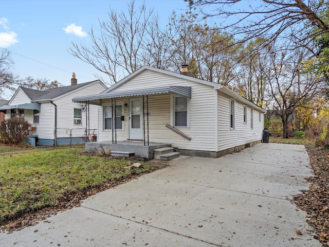 bungalow-style home featuring covered porch and a front yard