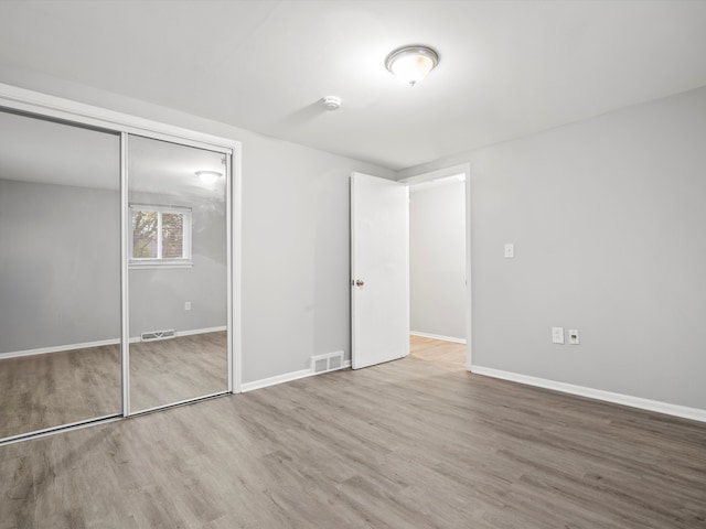 unfurnished bedroom featuring a closet and hardwood / wood-style floors