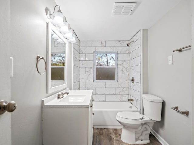 full bathroom with hardwood / wood-style flooring, vanity, toilet, and tiled shower / bath combo