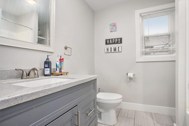 bathroom featuring vanity, walk in shower, and toilet