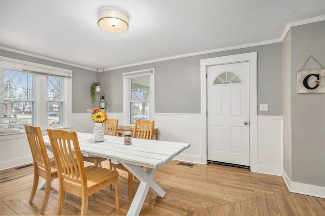 dining room with light parquet flooring and crown molding