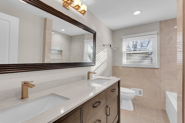 bathroom with tile patterned flooring, vanity, toilet, and tile walls