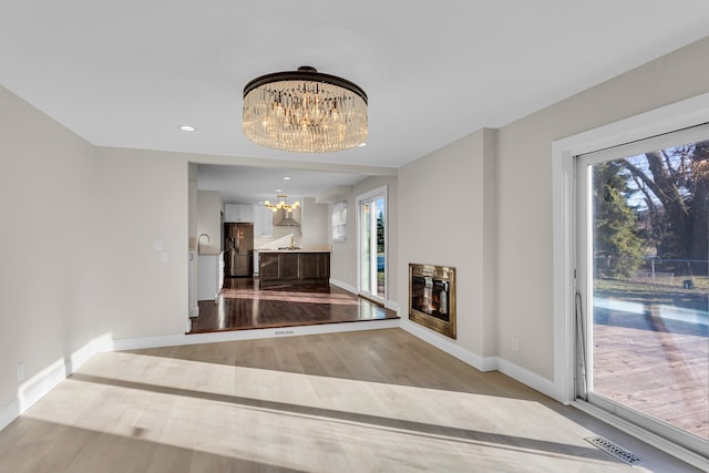 hallway featuring light hardwood / wood-style floors and a notable chandelier