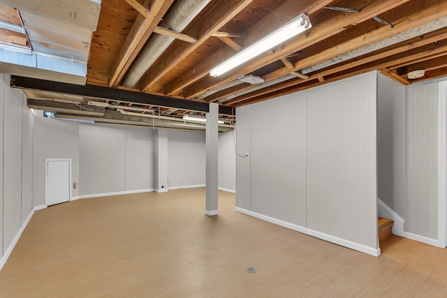 basement with light hardwood / wood-style flooring