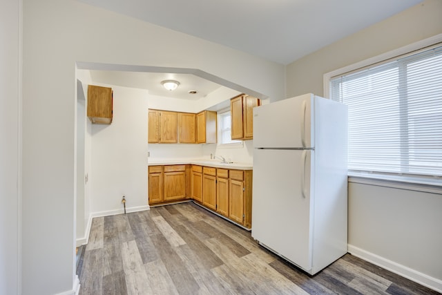 kitchen featuring white fridge, a wealth of natural light, light hardwood / wood-style floors, and sink