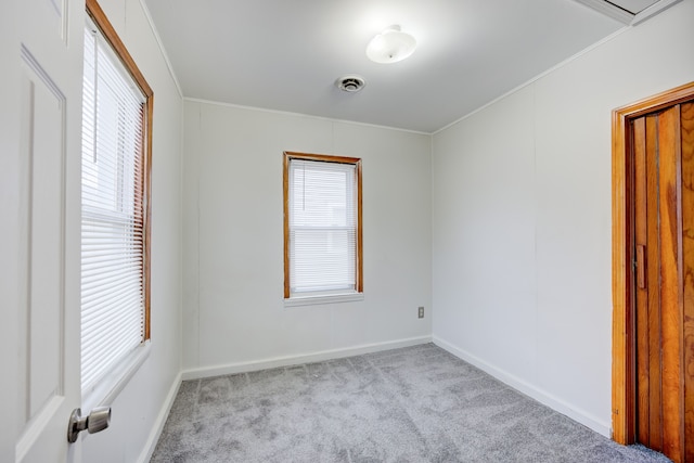 spare room featuring light carpet and crown molding