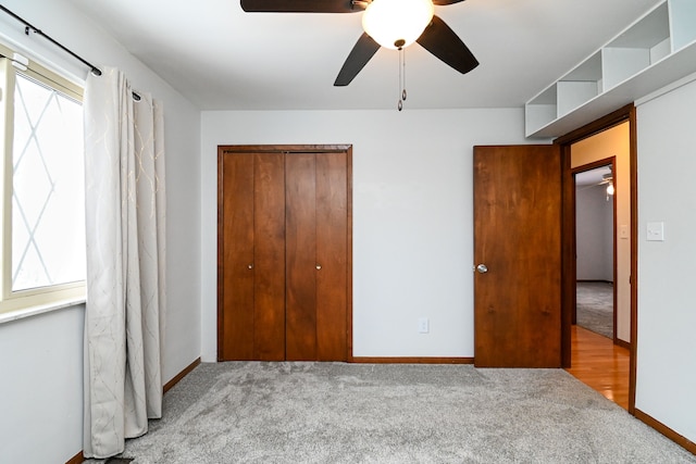 unfurnished bedroom with light carpet, ceiling fan, and a closet