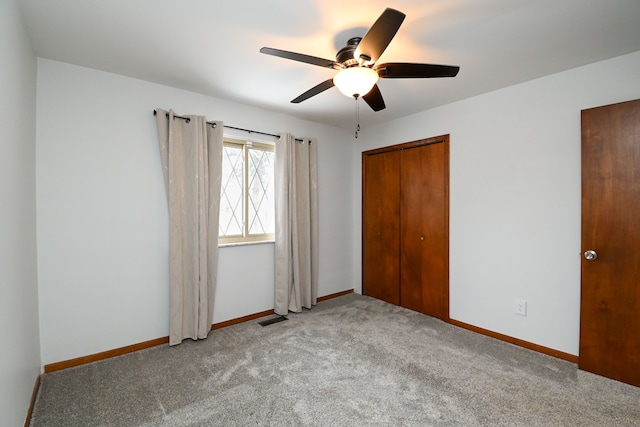 unfurnished bedroom featuring ceiling fan, a closet, and light carpet