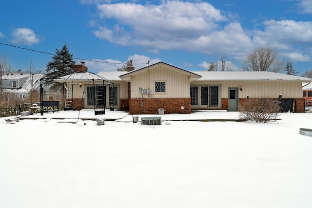 snow covered rear of property with a gazebo