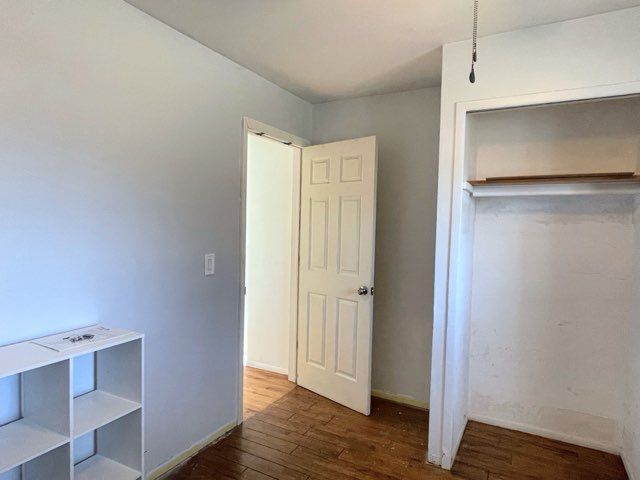 unfurnished bedroom with dark hardwood / wood-style floors