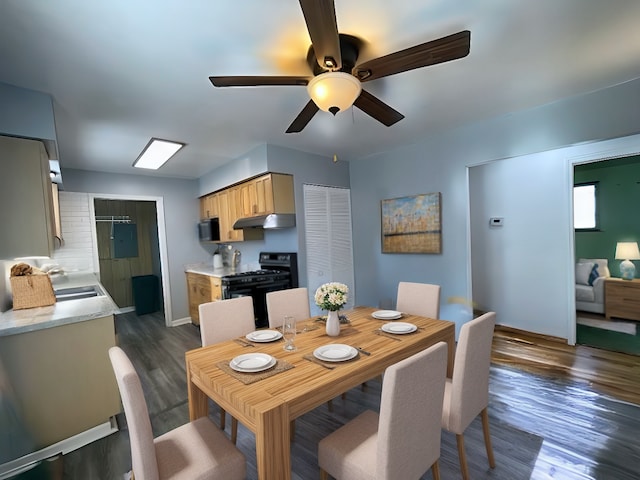 dining space with ceiling fan, dark wood-type flooring, and sink