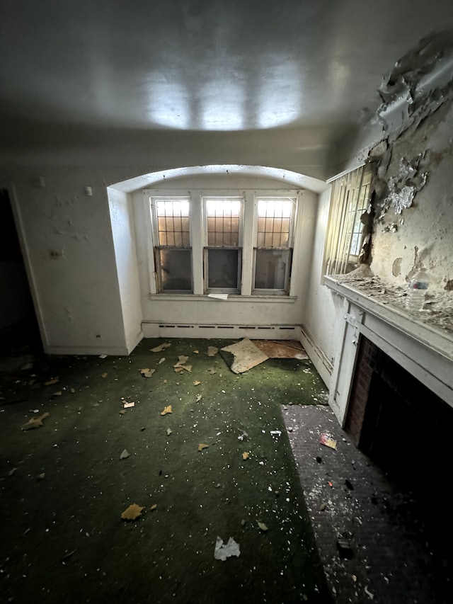 miscellaneous room featuring a baseboard heating unit and a fireplace