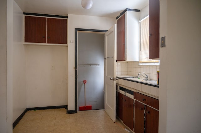 kitchen with tasteful backsplash, sink, and dark brown cabinets