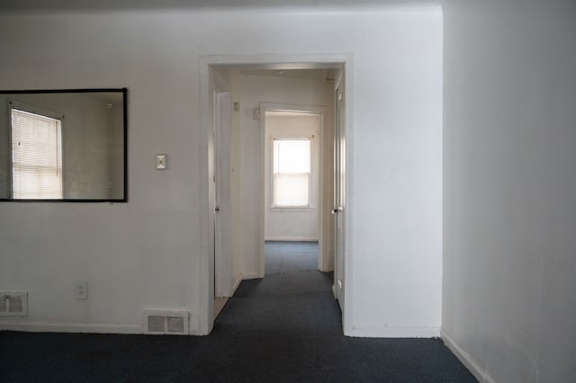 hallway featuring dark colored carpet