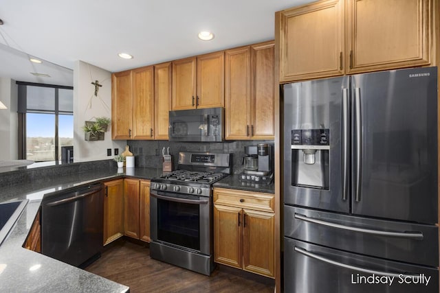 kitchen with backsplash, dark hardwood / wood-style flooring, stainless steel appliances, and dark stone counters