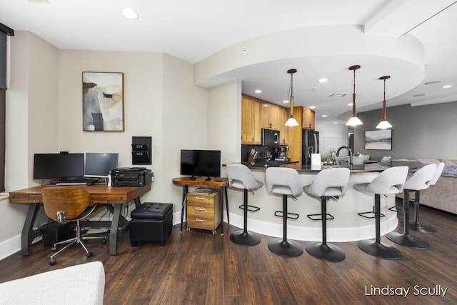 kitchen with black appliances, light brown cabinets, kitchen peninsula, and pendant lighting