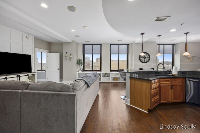 kitchen with pendant lighting, stainless steel dishwasher, dark wood-type flooring, and sink