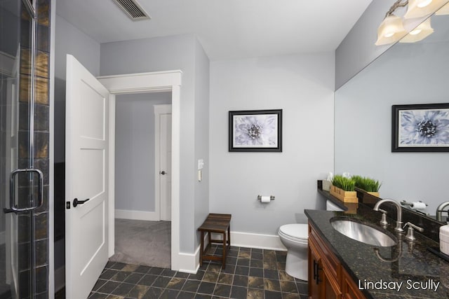 bathroom featuring a shower with door, vanity, and toilet