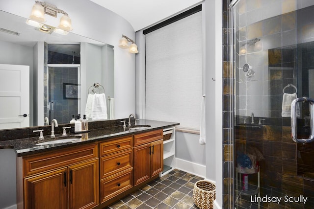 bathroom featuring a shower with door and vanity