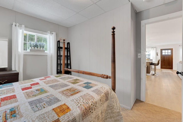 bedroom featuring a paneled ceiling and light carpet