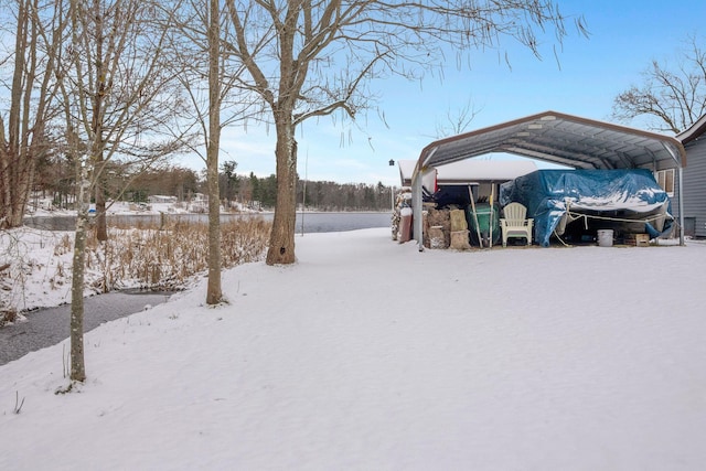 yard covered in snow featuring a carport