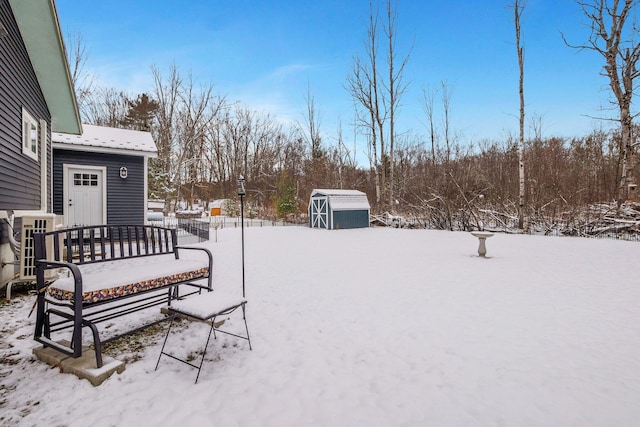 yard layered in snow with a shed