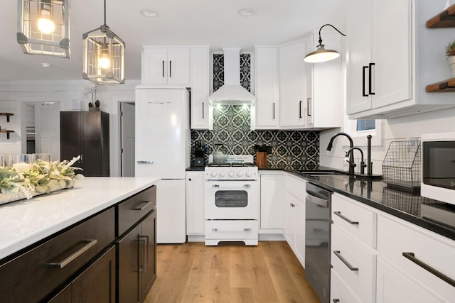 kitchen featuring decorative light fixtures, white appliances, premium range hood, and white cabinetry