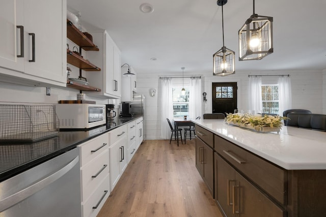 kitchen featuring dishwasher, pendant lighting, light hardwood / wood-style floors, and white cabinetry