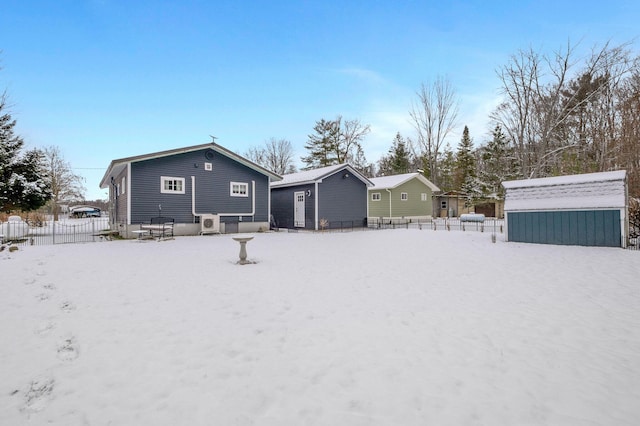 snow covered back of property with a shed