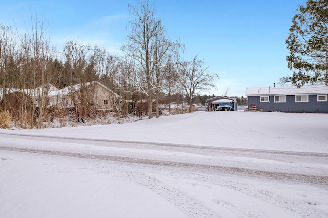 snowy yard with a carport