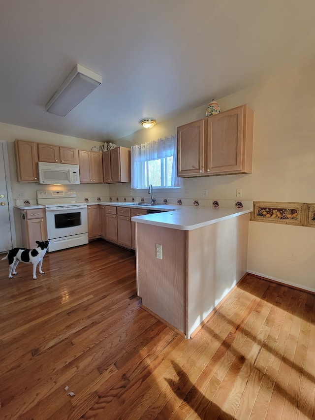 kitchen featuring kitchen peninsula, light brown cabinetry, light hardwood / wood-style floors, and white appliances