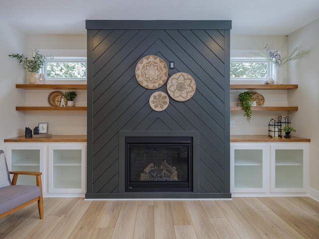 interior details with a large fireplace and hardwood / wood-style flooring