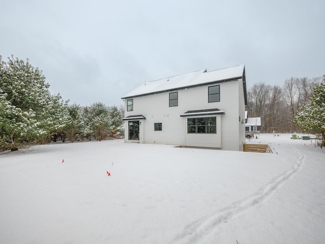 view of snow covered rear of property