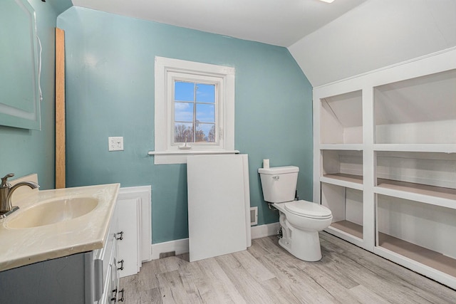 120 N Main St, Climax, MI 49034 - bathroom featuring vanity, lofted ceiling, wood finished floors, toilet, and baseboards