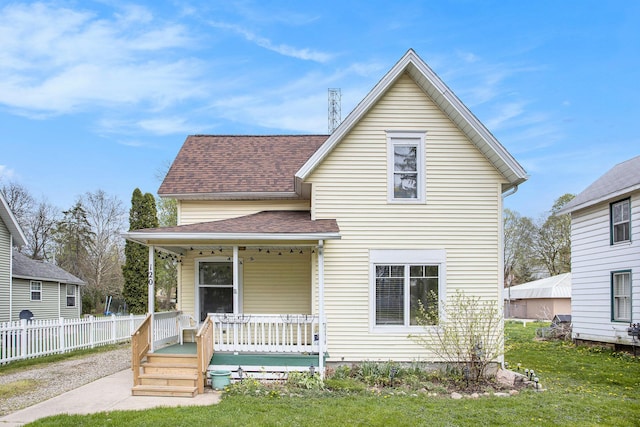 120 N Main St, Climax, MI 49034 - traditional-style house featuring roof with shingles, fence, a porch, and a front lawn